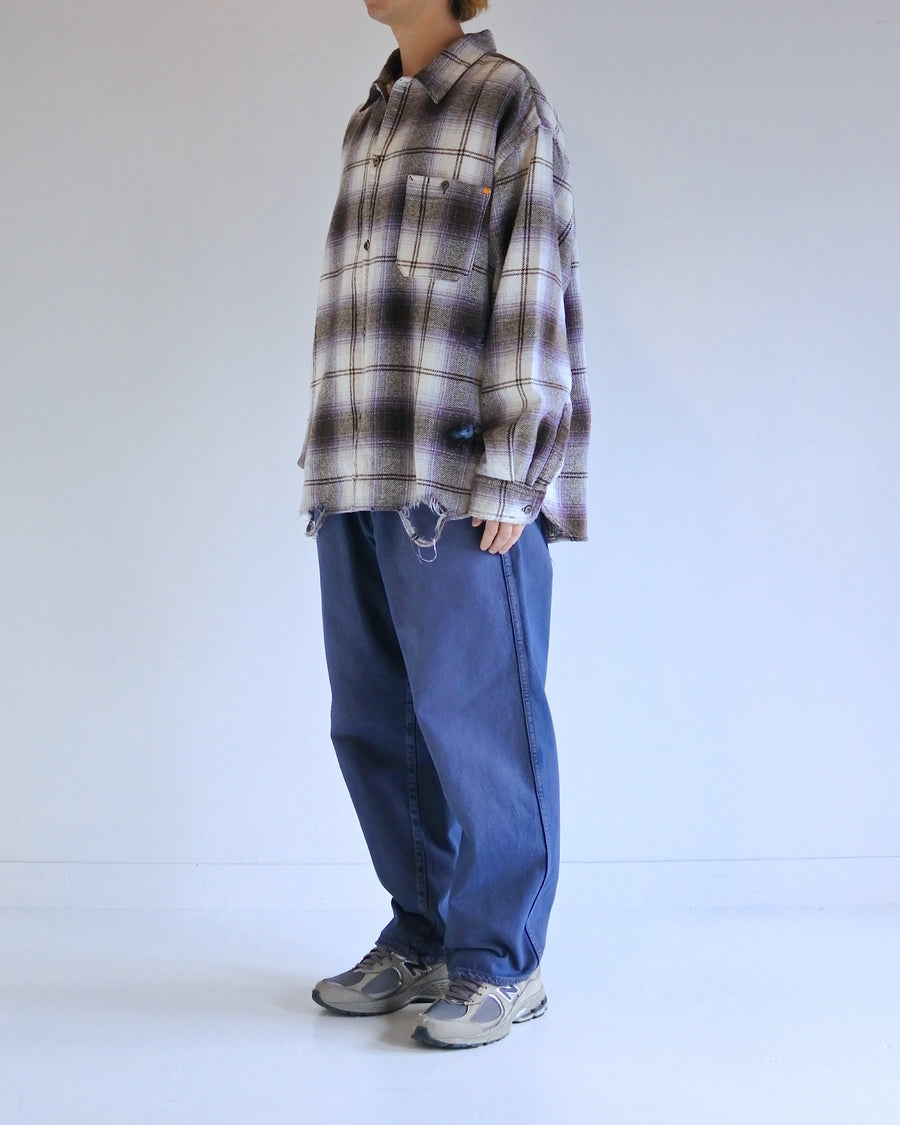 ANACHRONORMで以前リリースしていたリサイズシャツのシルエットをリファインした、ワイドシルエットシャツです。
随所に施された細かなステッチワークやダメージ加工にもご注目ください。
生地はリサイクルコットンとポリエステルを混紡したT/Cネップチェックで、起毛によるネップの風合いとメランジ染めの独特なムラ感が特徴です。
サスティナブルブリーチ加工とダメージ加工を施しており、環境に配慮しつつPURPLE×BLACKカラーで仕上げています。