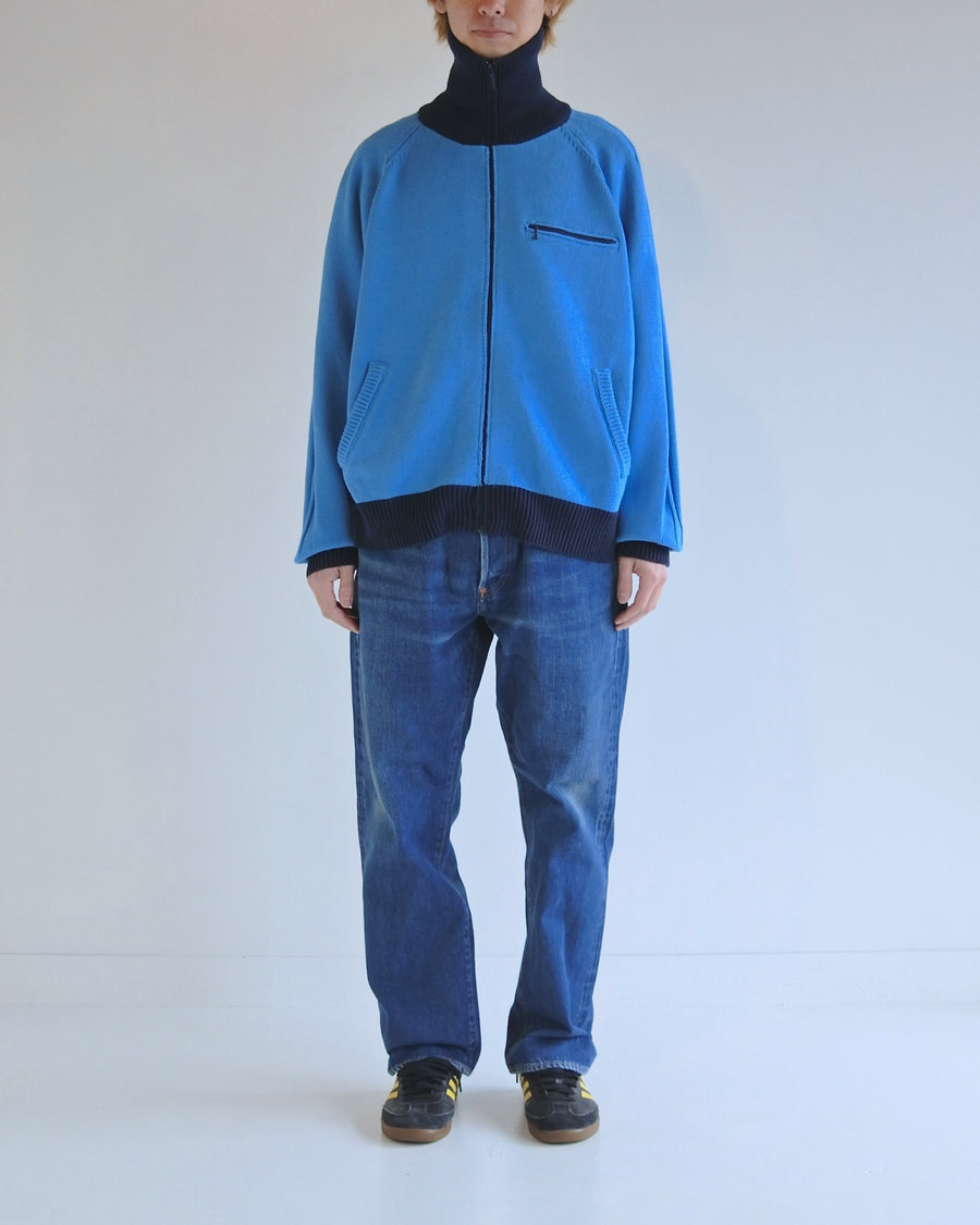 コットンニットを使用したドライバーズニット。
太番手の強撚糸による特殊な天竺編みで、適度なハリと風合いを持たせています。
ゆとりのある身幅ながら、アウターのインナーとしても使いやすいバランスの取れたシルエットに仕上げました。コットン素材のためホームクリーニングも可能です。
カラーは鮮やかなスカイブルー。