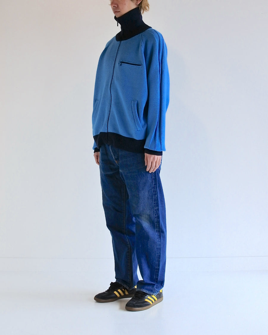 コットンニットを使用したドライバーズニット。
太番手の強撚糸による特殊な天竺編みで、適度なハリと風合いを持たせています。
ゆとりのある身幅ながら、アウターのインナーとしても使いやすいバランスの取れたシルエットに仕上げました。コットン素材のためホームクリーニングも可能です。
カラーは鮮やかなスカイブルー。