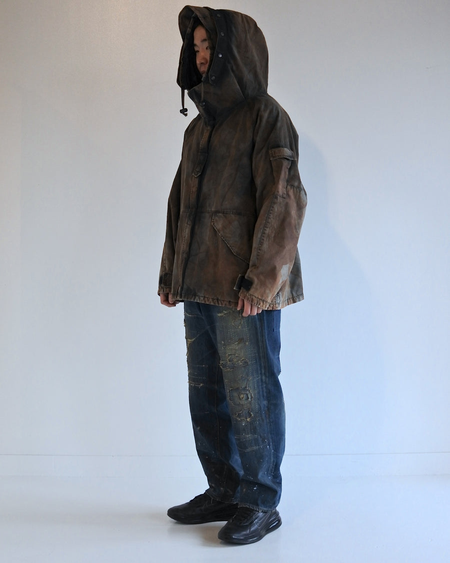 U.S. ARMYのフィールドジャケットをベースに再構築したパーカー。
中綿キルティングを採用し、重すぎず長いシーズン着用可能。
表地はパラフィンコーティングによる軽い撥水性を備えています。
20/リップストップ生地は裂けにくく、マットでしなやかな質感が特徴。
硫化染め後、水を一切使わないサステナブルブリーチを施した特別加工。
独特の風合いと環境配慮を両立した一着です。
A refined take on the U.S. Army field jacket silhouette.
Medium-weight quilted padding offers seasonal versatility without excess bulk.
The paraffin-coated shell provides light water repellency.
Crafted from durable 20/ripstop with a matte, supple texture.
Finished with sulfide dye and a fully water-free sustainable bleachi