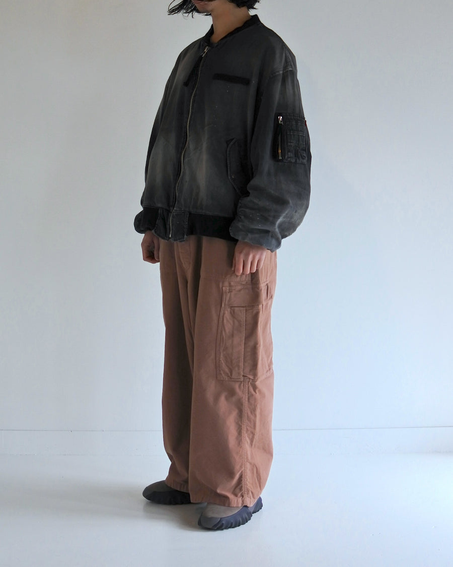 【 商品名：エイジングデュアルデニムMA-1 】

本製品は、ブランドのメイン素材であるデニムを使用し、ディティールを忠実に再現しながらシルエットを整えたブラックカラーのMA-1ジャケットです。中綿は入っていませんが、ライトオンスデニムを採用し、二重縫製によって柔らかく程よい肉感のある着心地に仕上げています。生地にはムラ糸を使用した8ozデニムを採用しており、シャープなムラ形状と粗野な風合いがより一層ヴィンテージ感を引き立てます。さらに加工には、全体にリアルなアタリ感を与えるエイジング加工を施し、深みのある表情を持たせています。