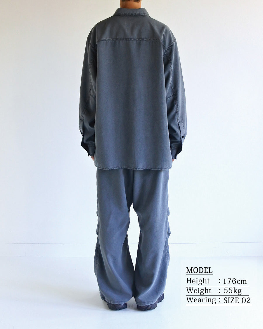 ポリエステル100％ながら、綿のような質感と軽量性を備えた高機能素材を採用。タスラン加工糸を使用したポリエステルオックスは、シワになりにくく速乾性にも優れています。本来染色が困難な素材に特殊顔料染めを施すことで、化繊特有の光沢を抑え、ナチュラルで奥行きのある絶妙なフェード感と落ち着いた表情を実現しました。

A high-performance piece crafted from polyester oxford, offering a cotton-like touch with quick-dry and wrinkle-resistant benefits. This GRAY BEIGE item features a special pigment dye—a rare process for polyester—achieving a sophisticated, faded texture and a matte finish that perfectly balances technical utility with a natural, lived-in aesthetic.