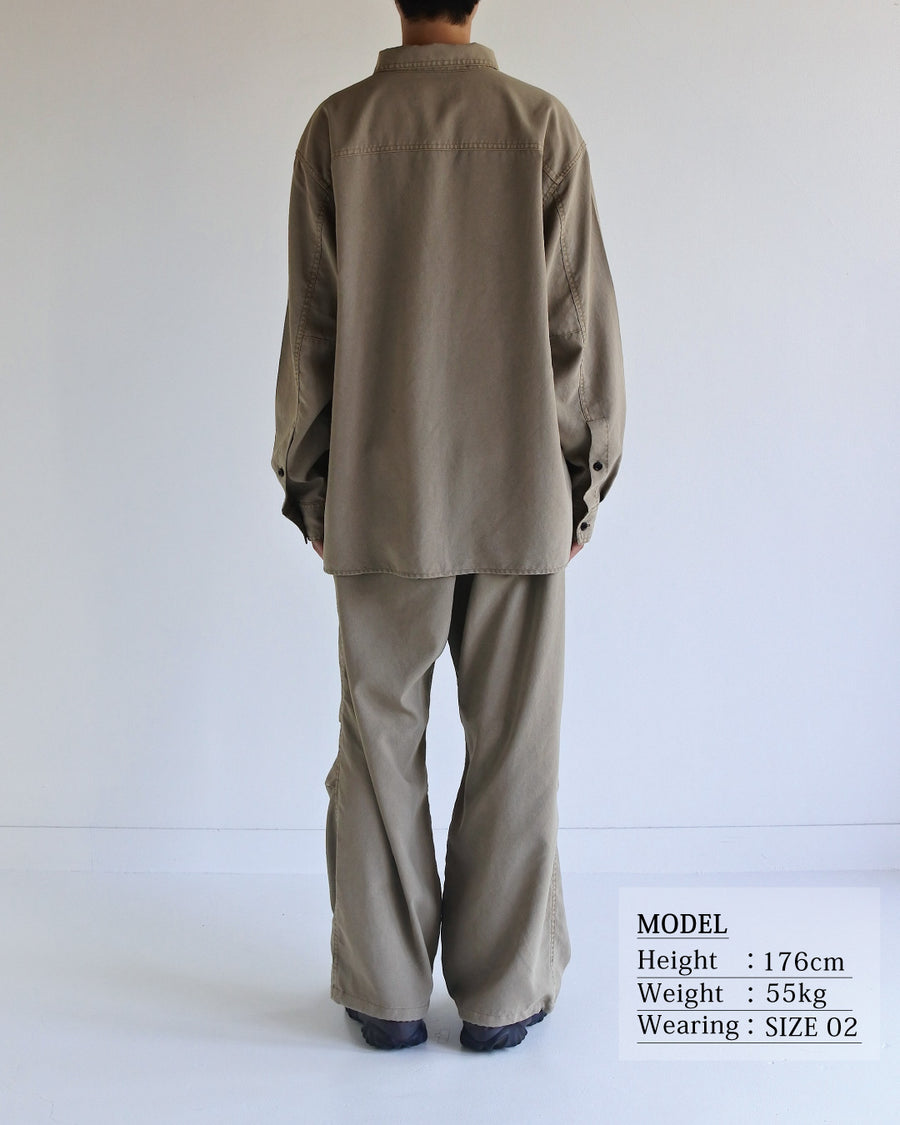 ポリエステル100％ながら、綿のような質感と軽量性を備えた高機能素材を採用。タスラン加工糸を使用したポリエステルオックスは、シワになりにくく速乾性にも優れています。本来染色が困難な素材に特殊顔料染めを施すことで、化繊特有の光沢を抑え、ナチュラルで奥行きのある絶妙なフェード感と落ち着いた表情を実現しました。

A high-performance piece crafted from polyester oxford, offering a cotton-like touch with quick-dry and wrinkle-resistant benefits. This GRAY BEIGE item features a special pigment dye—a rare process for polyester—achieving a sophisticated, faded texture and a matte finish that perfectly balances technical utility with a natural, lived-in aesthetic.