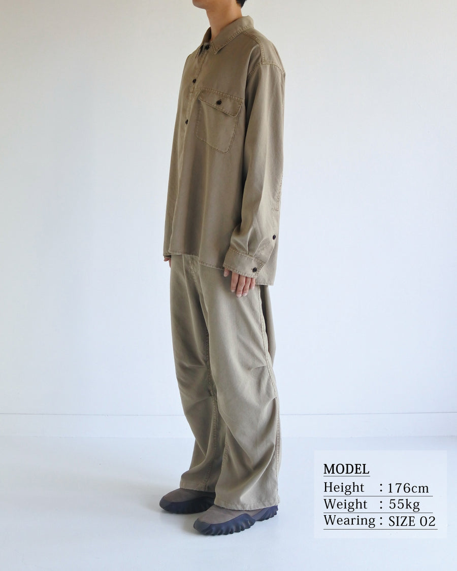 ポリエステル100％ながら、綿のような質感と軽量性を備えた高機能素材を採用。タスラン加工糸を使用したポリエステルオックスは、シワになりにくく速乾性にも優れています。本来染色が困難な素材に特殊顔料染めを施すことで、化繊特有の光沢を抑え、ナチュラルで奥行きのある絶妙なフェード感と落ち着いた表情を実現しました。

A high-performance piece crafted from polyester oxford, offering a cotton-like touch with quick-dry and wrinkle-resistant benefits. This GRAY BEIGE item features a special pigment dye—a rare process for polyester—achieving a sophisticated, faded texture and a matte finish that perfectly balances technical utility with a natural, lived-in aesthetic.