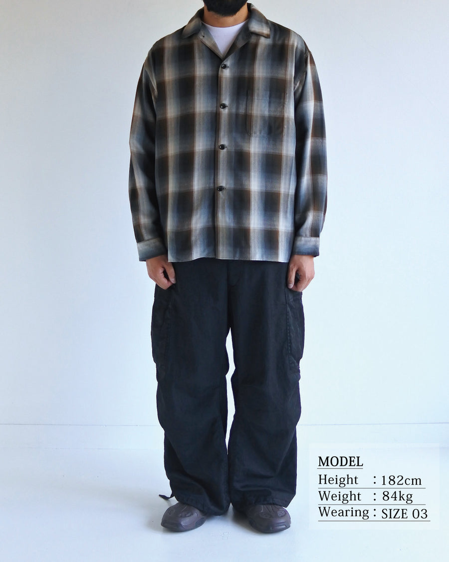 オンブレチェック柄が目を惹くオープンカラーシャツ。生地が持つ自然なドレープ感を活かし、リラックス感のあるゆとりを持たせたシルエットに仕上げました。素材にはタテ・ヨコ共にレーヨン糸を使用したレーヨンチェックを採用。非常に優れた落ち感と、袖を通した瞬間に感じる滑らかで心地よい肌触りが、上質なリラックススタイルを演出します。

An open-collar shirt featuring a classic ombre check pattern. The relaxed silhouette highlights the natural drape and fluid movement of the fabric. Crafted from a high-quality rayon check weave, this BLUE CHECK piece is characterized by its exceptional softness and smooth touch, offering a sophisticated look with an effortlessly comfortable feel.