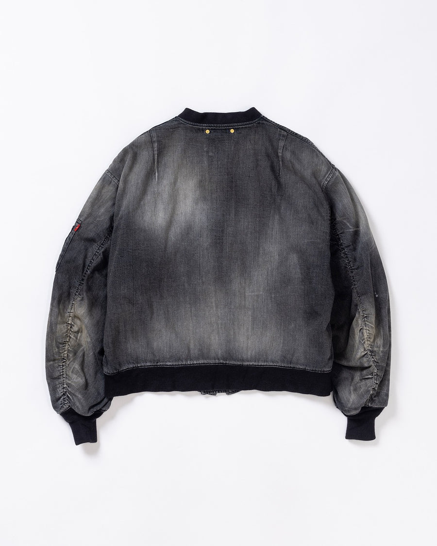 【 商品名：エイジングデュアルデニムMA-1 】

本製品は、ブランドのメイン素材であるデニムを使用し、ディティールを忠実に再現しながらシルエットを整えたブラックカラーのMA-1ジャケットです。中綿は入っていませんが、ライトオンスデニムを採用し、二重縫製によって柔らかく程よい肉感のある着心地に仕上げています。生地にはムラ糸を使用した8ozデニムを採用しており、シャープなムラ形状と粗野な風合いがより一層ヴィンテージ感を引き立てます。さらに加工には、全体にリアルなアタリ感を与えるエイジング加工を施し、深みのある表情を持たせています。