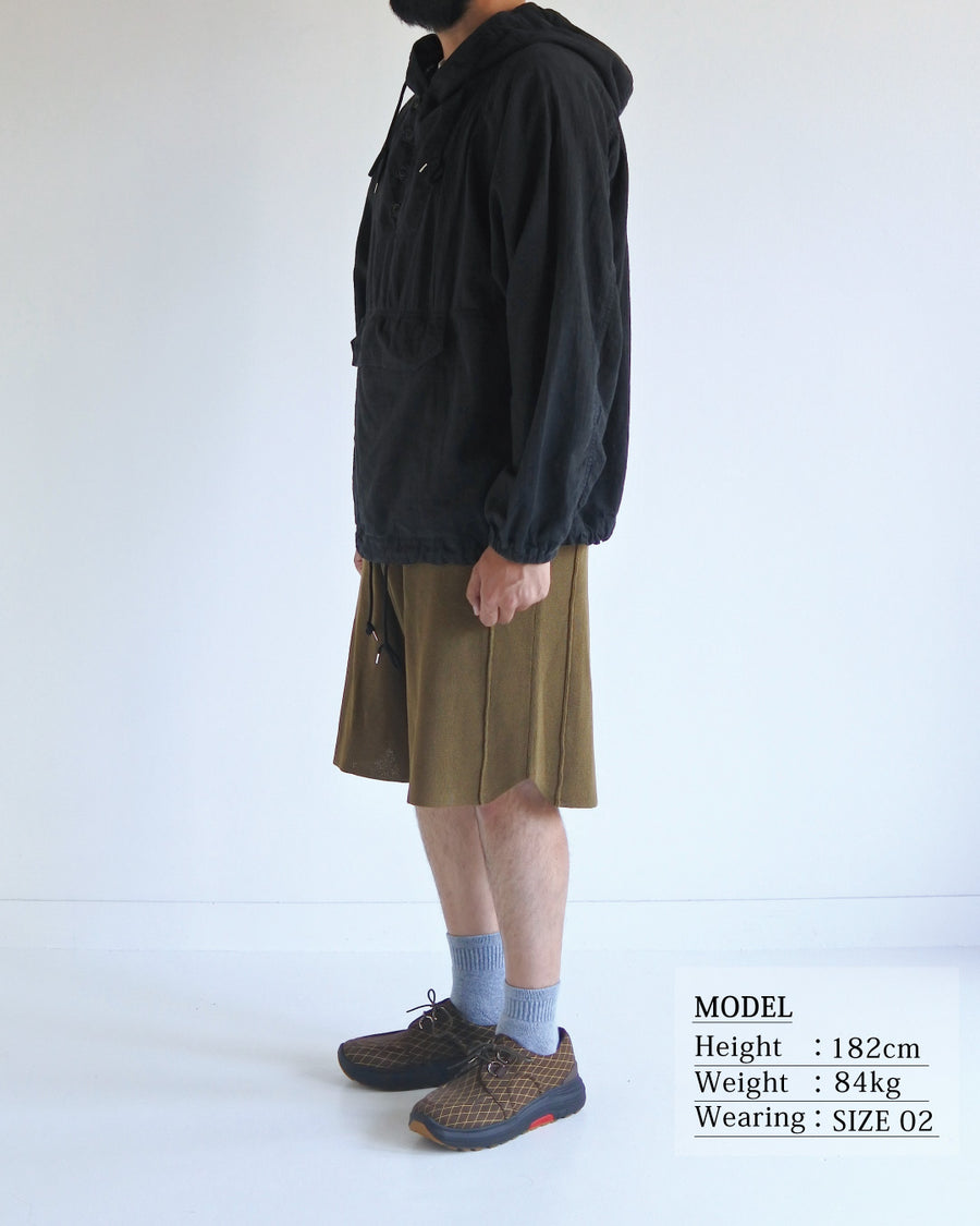 フード口のボタンの開閉により、首周りのニュアンスを自在に調整できる一着。素材には、麻カスや節を活かしたネップ糸を織り交ぜたコットンリネンチェックを採用しました。ドライタッチな生地にワンウォッシュを施すことで、麻特有のハリ感を残しつつ、肌馴染みの良い柔らかな風合いと豊かな表情を引き出しています。

This piece features adjustable hood buttons to alternate between a clean look and a relaxed neckline. Crafted from a cotton-linen check weave with rustic nep yarns, it highlights the natural texture of the fibers. The BLACK fabric is one-washed to balance a crisp, dry touch with a soft, broken-in feel, creating a sophisticated yet comfortable aesthetic.
