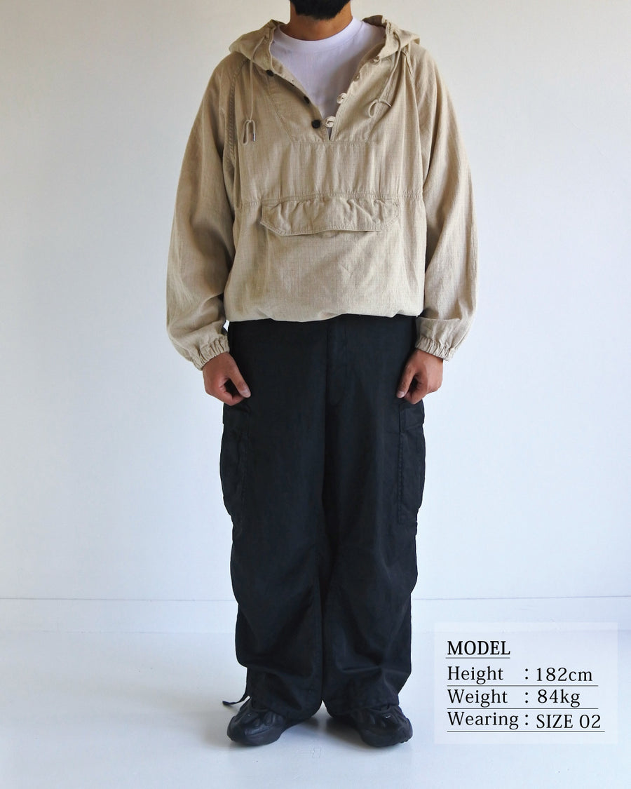 フード口のボタンの開閉により、首周りのニュアンスを自在に調整できる一着。素材には、麻カスや節を活かしたネップ糸を織り交ぜたコットンリネンチェックを採用しました。ドライタッチな生地にワンウォッシュを施すことで、麻特有のハリ感を残しつつ、肌馴染みの良い柔らかな風合いと豊かな表情を引き出しています。

This piece features adjustable hood buttons to alternate between a clean look and a relaxed neckline. Crafted from a cotton-linen check weave with rustic nep yarns, it highlights the natural texture of the fibers. The BEIGE fabric is one-washed to balance a crisp, dry touch with a soft, broken-in feel, creating a sophisticated yet comfortable aesthetic.
