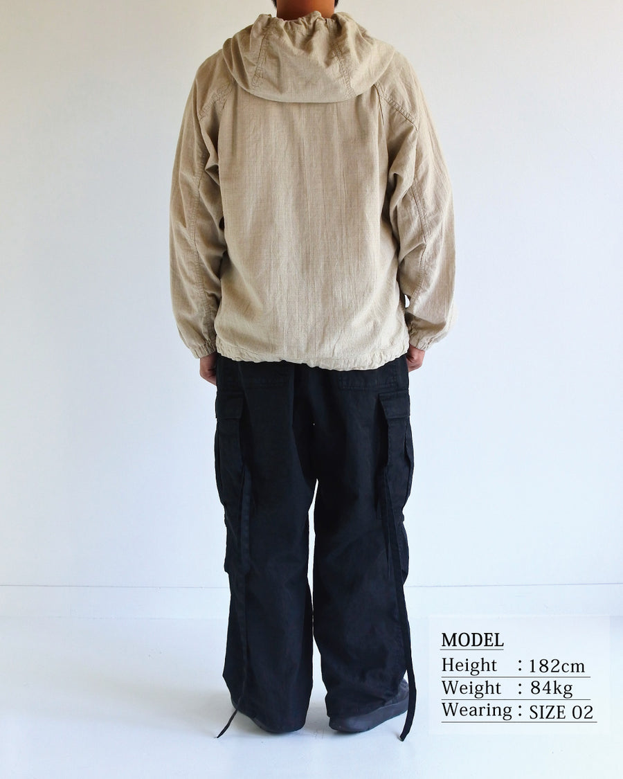 フード口のボタンの開閉により、首周りのニュアンスを自在に調整できる一着。素材には、麻カスや節を活かしたネップ糸を織り交ぜたコットンリネンチェックを採用しました。ドライタッチな生地にワンウォッシュを施すことで、麻特有のハリ感を残しつつ、肌馴染みの良い柔らかな風合いと豊かな表情を引き出しています。

This piece features adjustable hood buttons to alternate between a clean look and a relaxed neckline. Crafted from a cotton-linen check weave with rustic nep yarns, it highlights the natural texture of the fibers. The BEIGE fabric is one-washed to balance a crisp, dry touch with a soft, broken-in feel, creating a sophisticated yet comfortable aesthetic.
