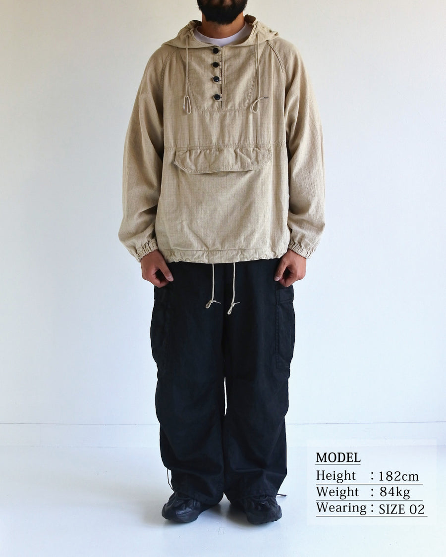 フード口のボタンの開閉により、首周りのニュアンスを自在に調整できる一着。素材には、麻カスや節を活かしたネップ糸を織り交ぜたコットンリネンチェックを採用しました。ドライタッチな生地にワンウォッシュを施すことで、麻特有のハリ感を残しつつ、肌馴染みの良い柔らかな風合いと豊かな表情を引き出しています。

This piece features adjustable hood buttons to alternate between a clean look and a relaxed neckline. Crafted from a cotton-linen check weave with rustic nep yarns, it highlights the natural texture of the fibers. The BEIGE fabric is one-washed to balance a crisp, dry touch with a soft, broken-in feel, creating a sophisticated yet comfortable aesthetic.
